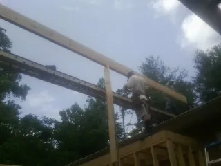 Carpenter setting a ridge beam over a new addition frame — Ice Dam Removal by Roofing Brothers in Haubstadt