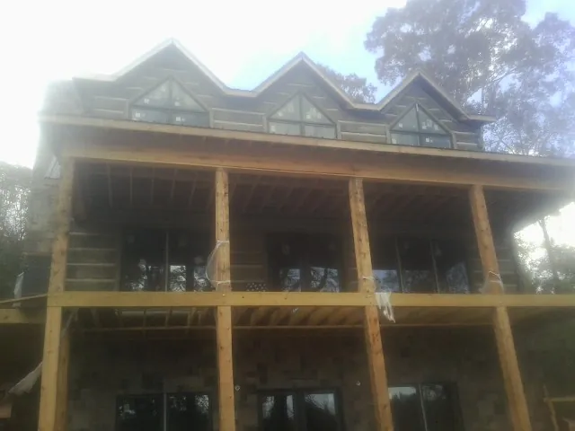 Dormers and porch framing on a large log home under construction — Roof Coating work by our crew in Haubstadt