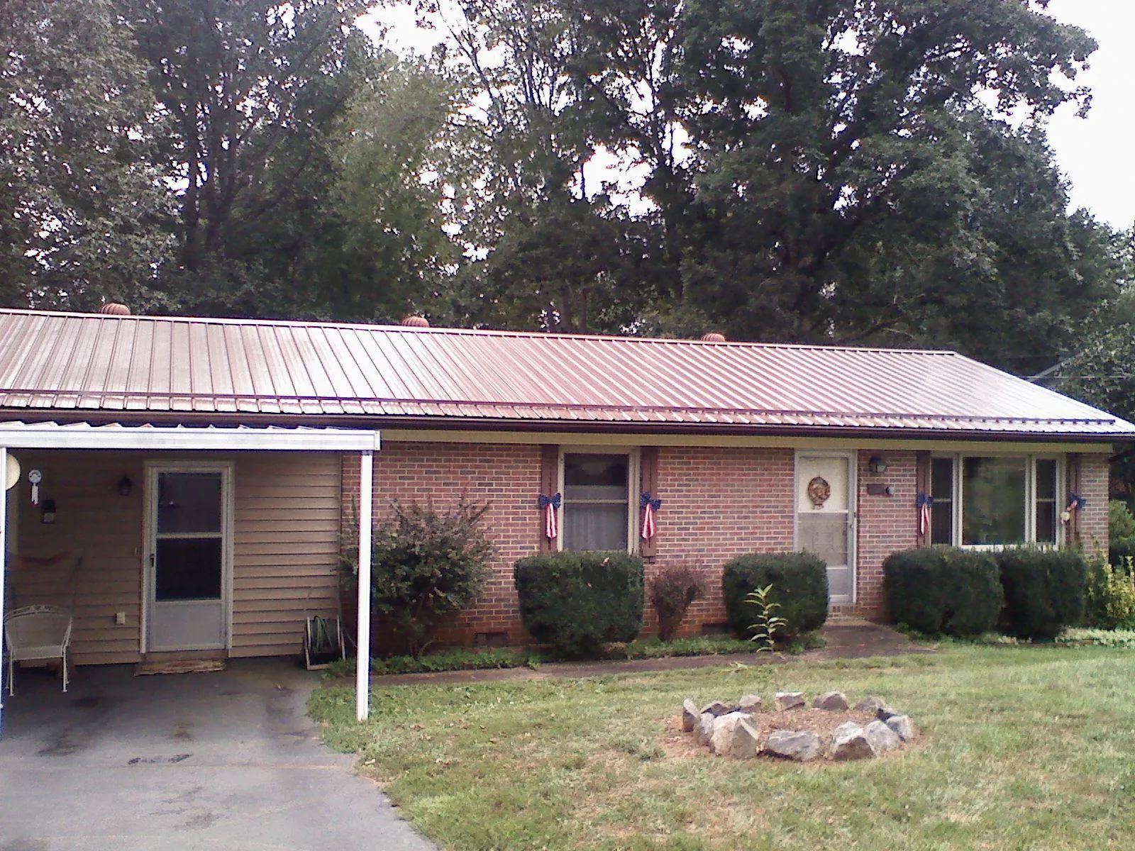 Bronze metal roof and carport on a brick ranch home — Roof Repair work by our crew in Haubstadt